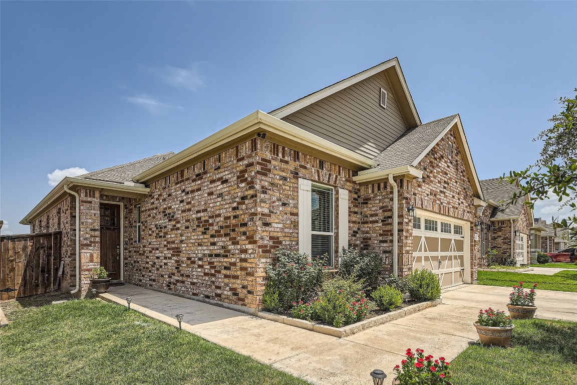 The side view and entrance of 209 Fort William #14 are displayed, highlighting the exquisite brickwork and the well-maintained landscaping.