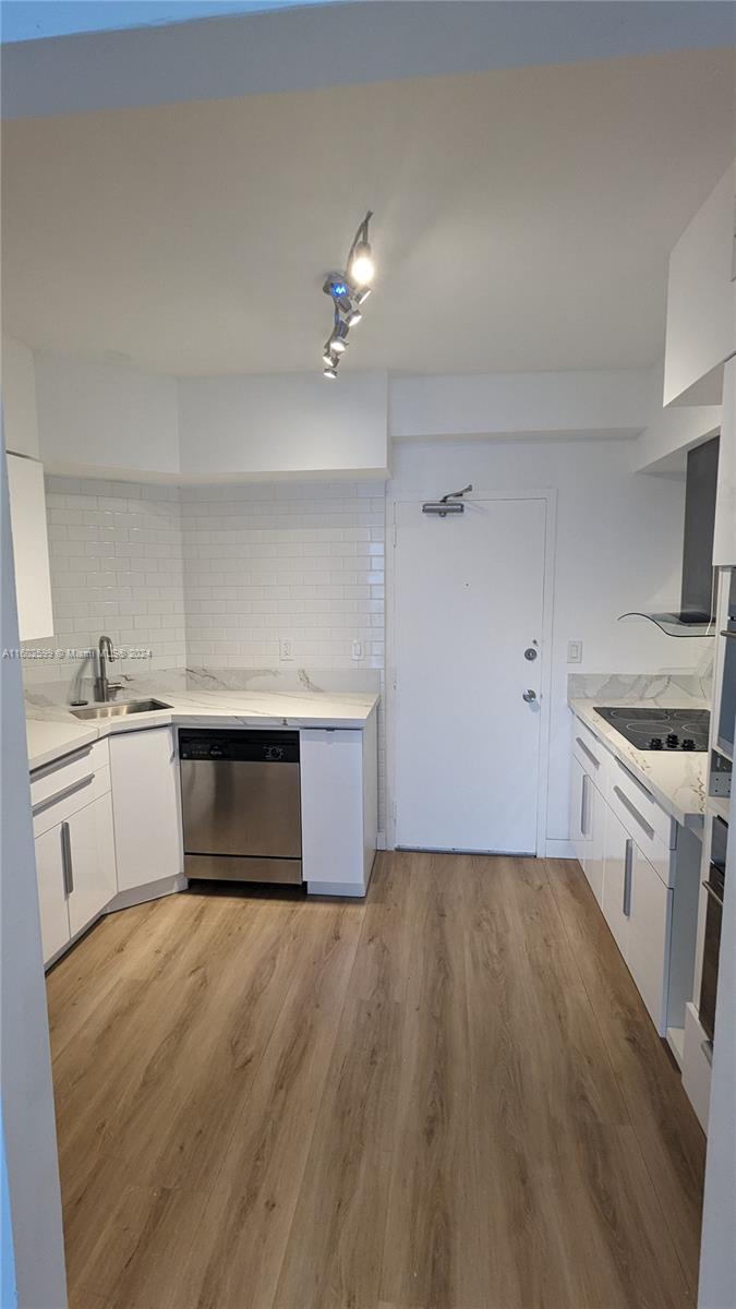 a kitchen with a stove sink and cabinets