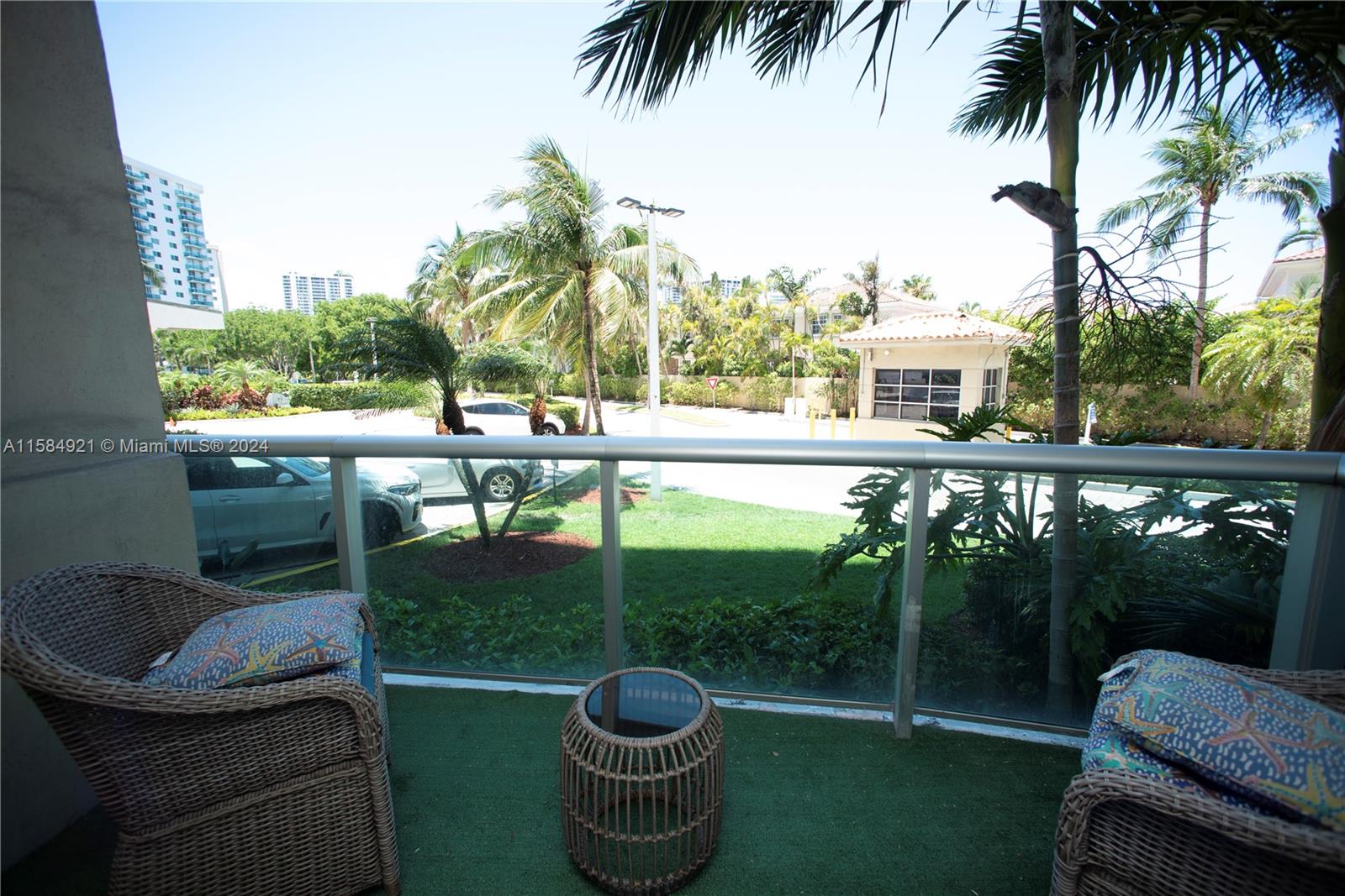 a balcony with table and chairs potted plants and palm trees