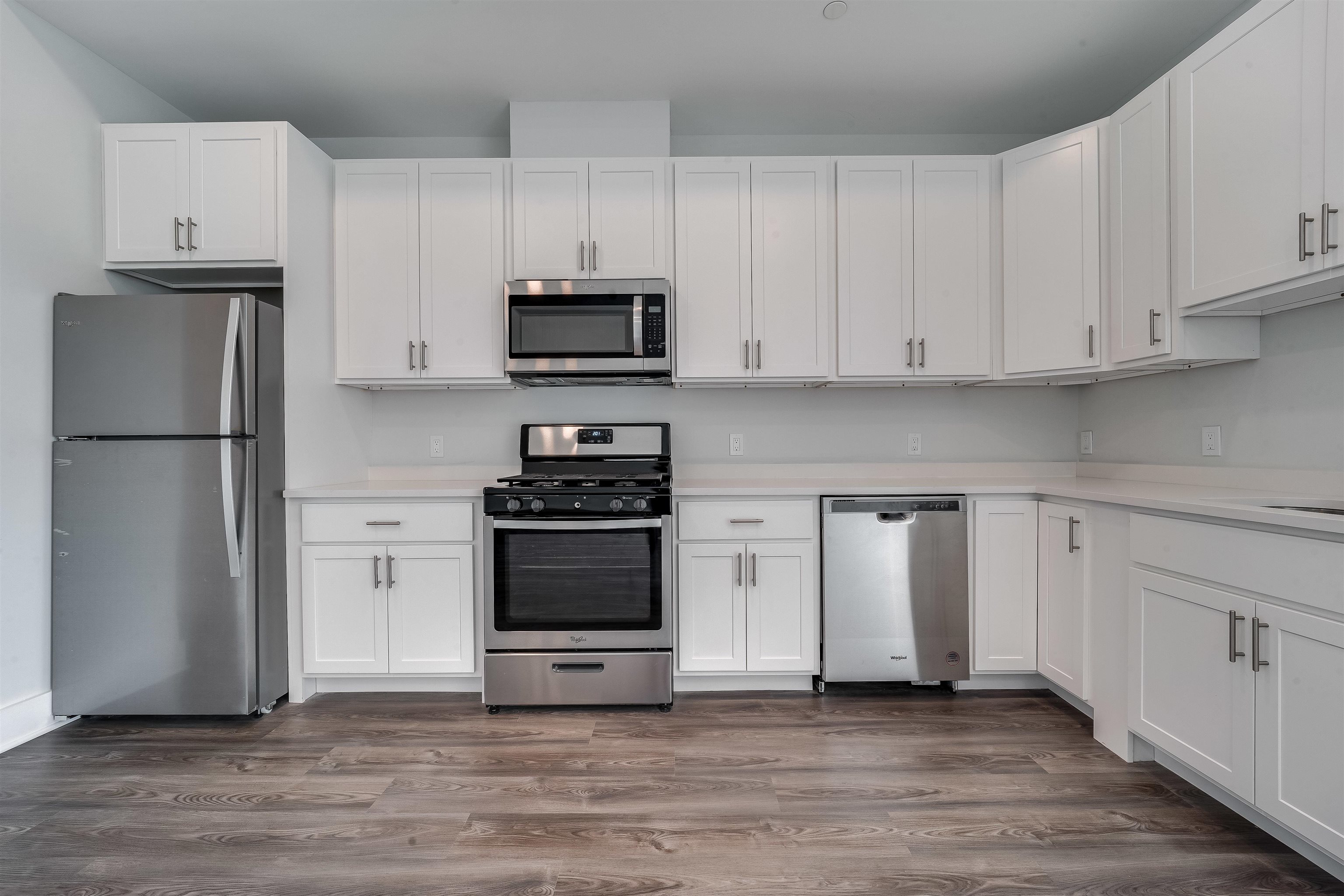 a kitchen with white cabinets and stainless steel appliances