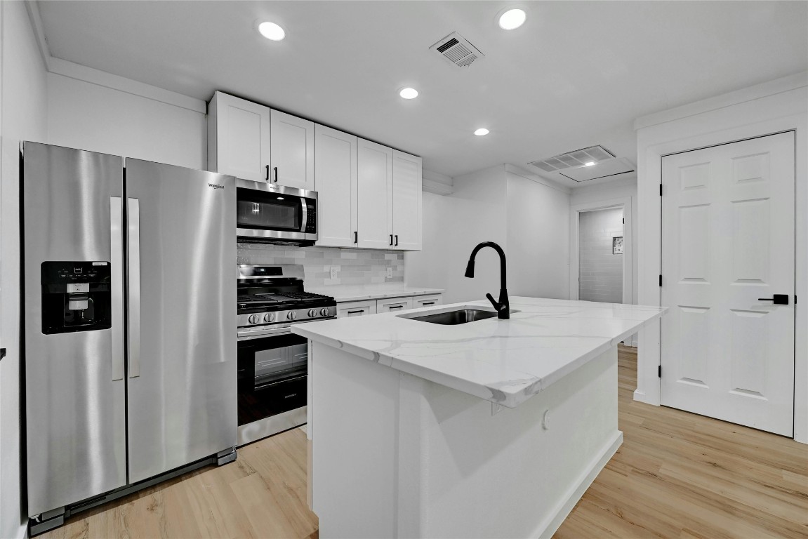 a kitchen with stainless steel appliances a sink stove and refrigerator