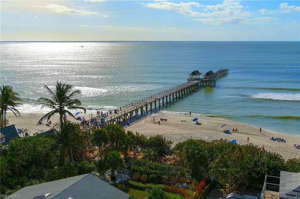 Birds eye view of property with a water view and a view of the beach