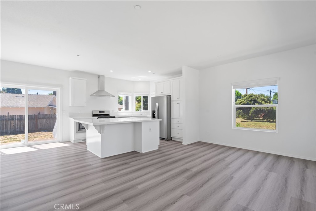 a view of kitchen with wooden floor and electronic appliances