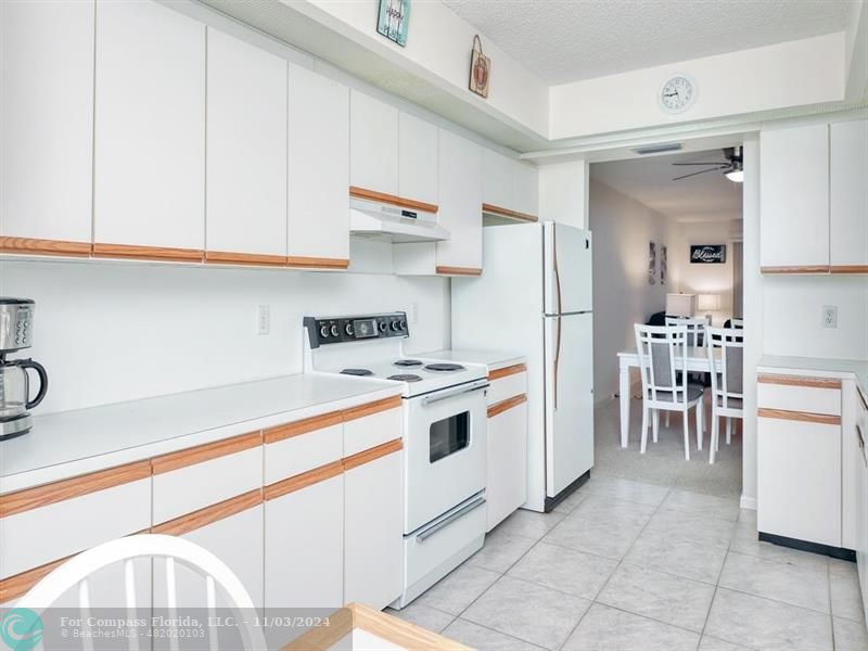 a kitchen with white cabinets and white appliances