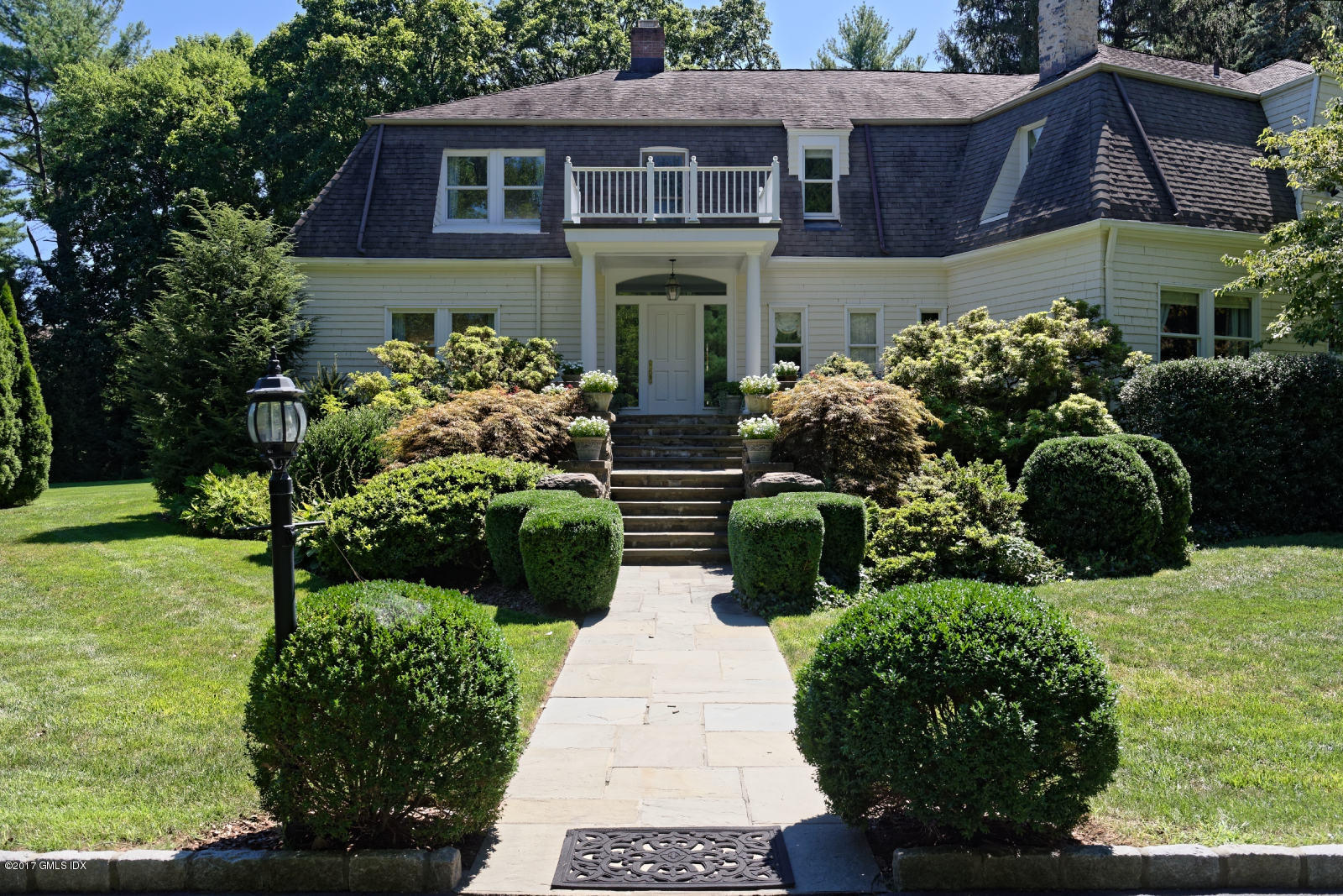 a view of a house with a yard and potted plants