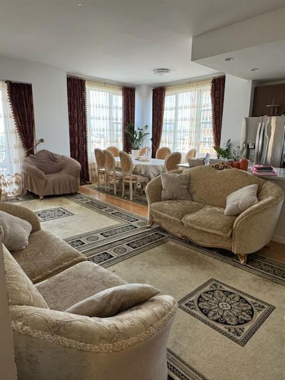 a living room with furniture kitchen view and a window