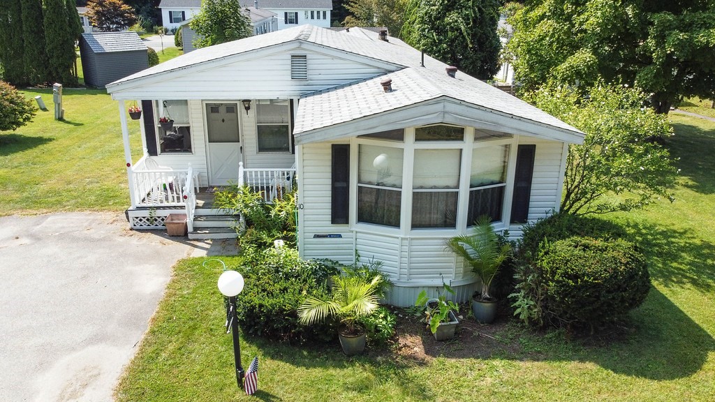 a front view of a house with a yard and potted plants