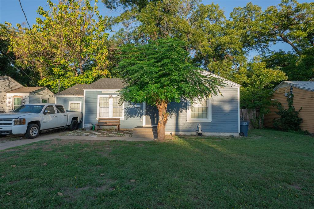 a front view of a house with a yard and trees