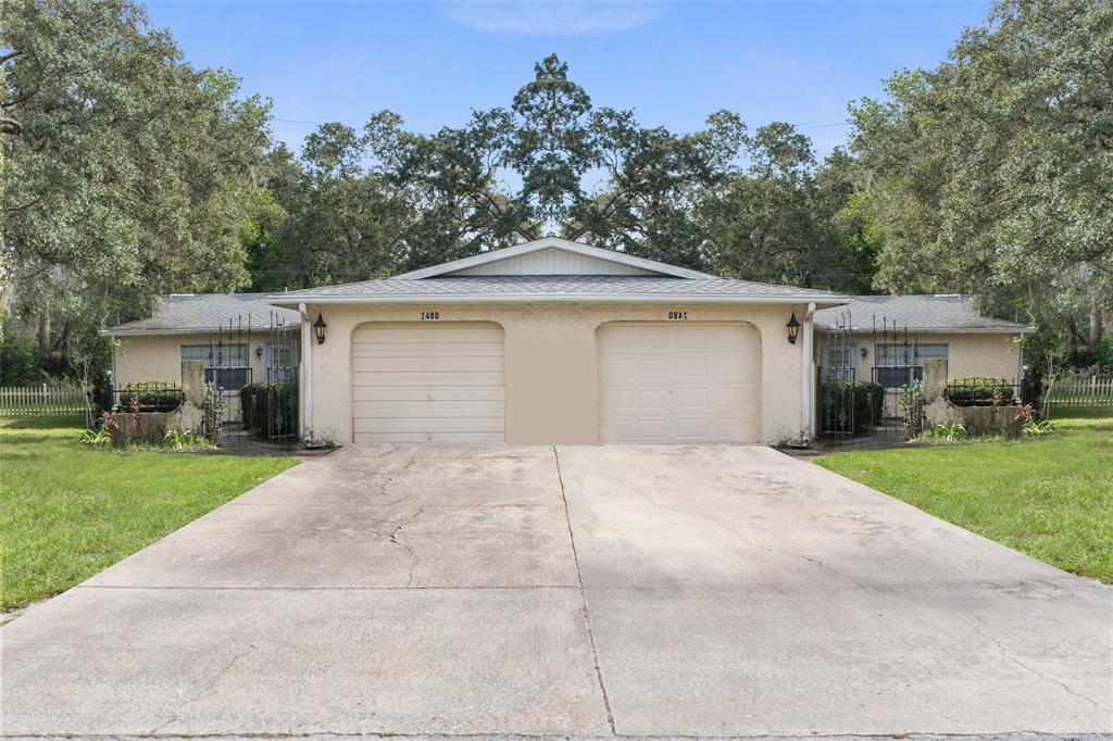 front view of a house with a yard and trees