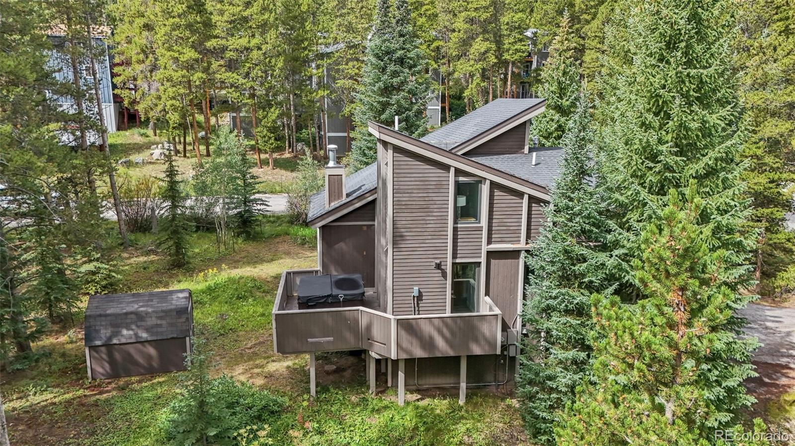 a backyard of a house with table and chairs large trees