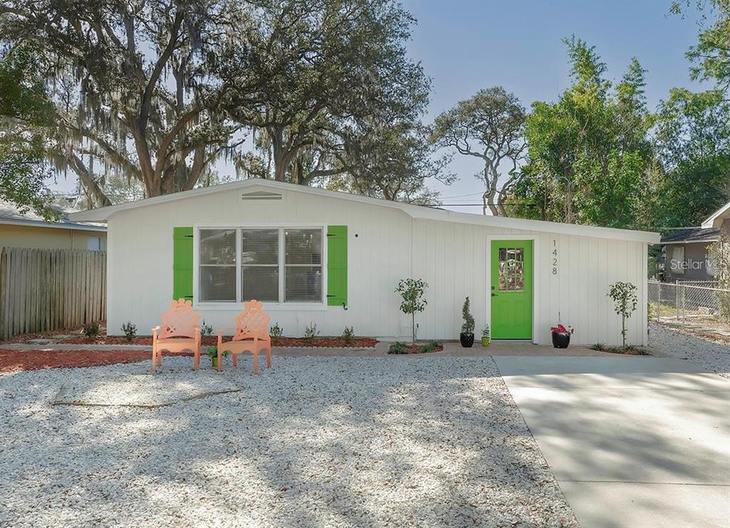 a front view of a house with a yard and seating space