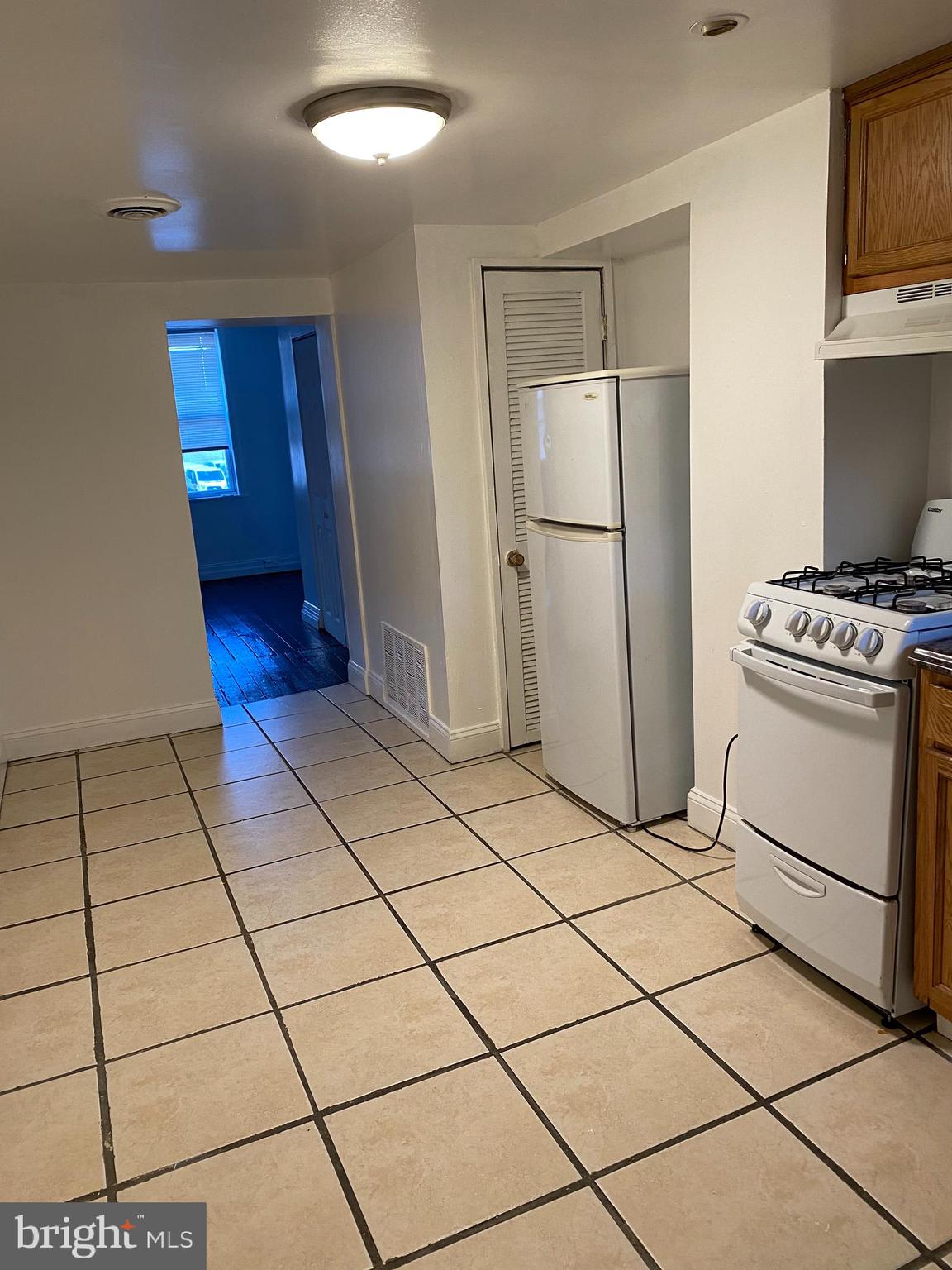 a kitchen with a stove a refrigerator and cabinets