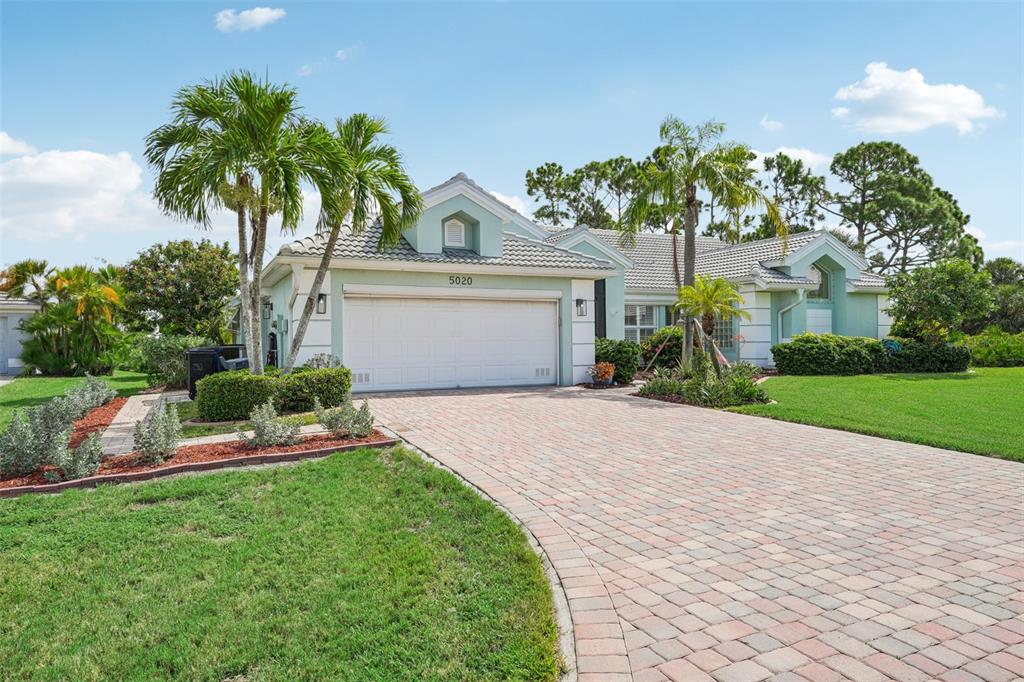 a front view of a house with a garden and a yard