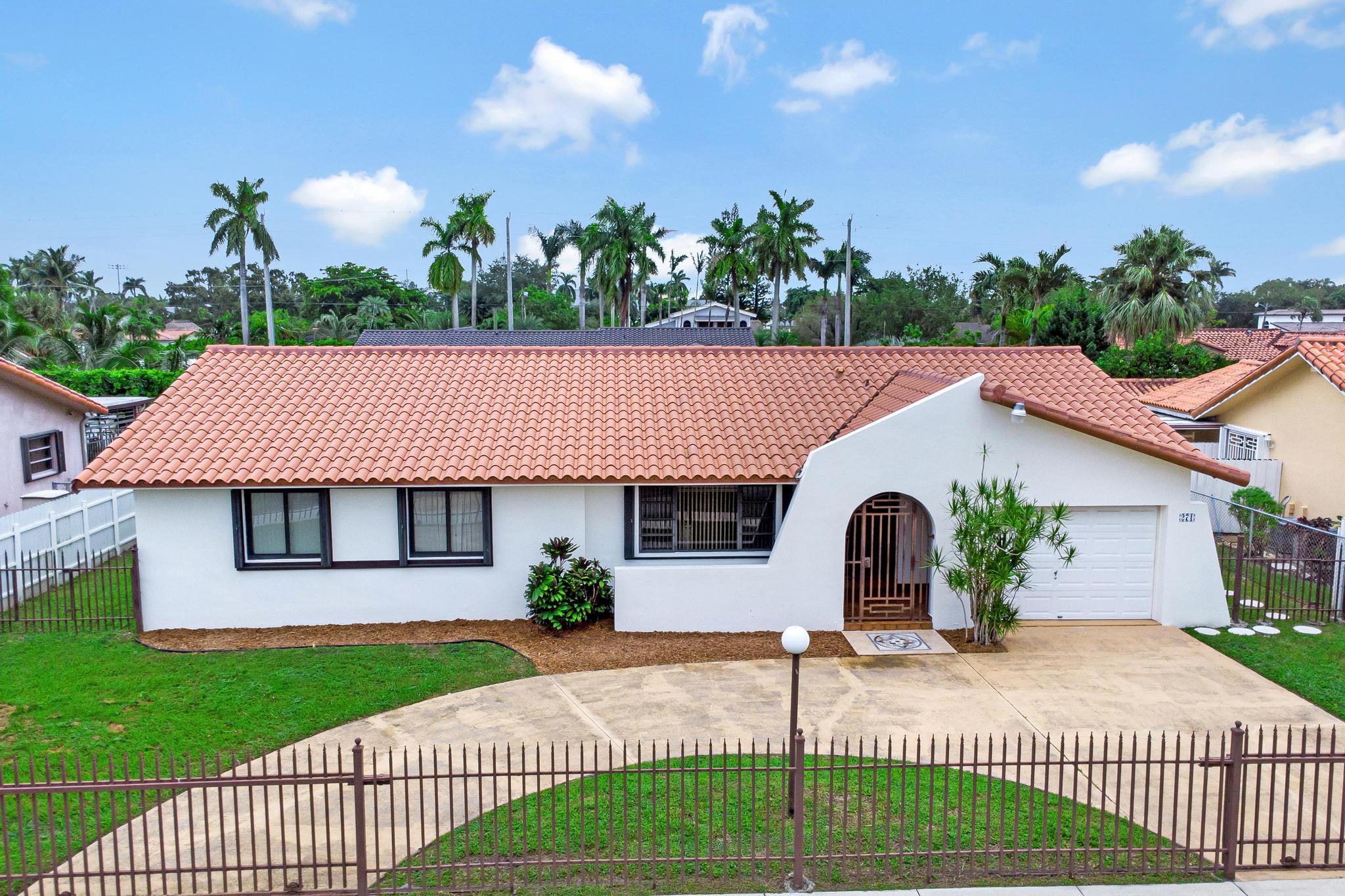 a front view of a house with a garden and plants