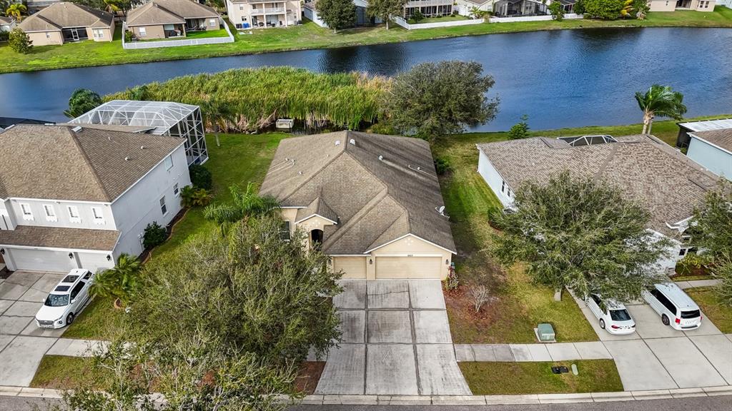 an aerial view of a house with a yard and lake view