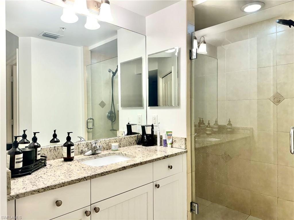 Bathroom with vanity and a shower with shower door