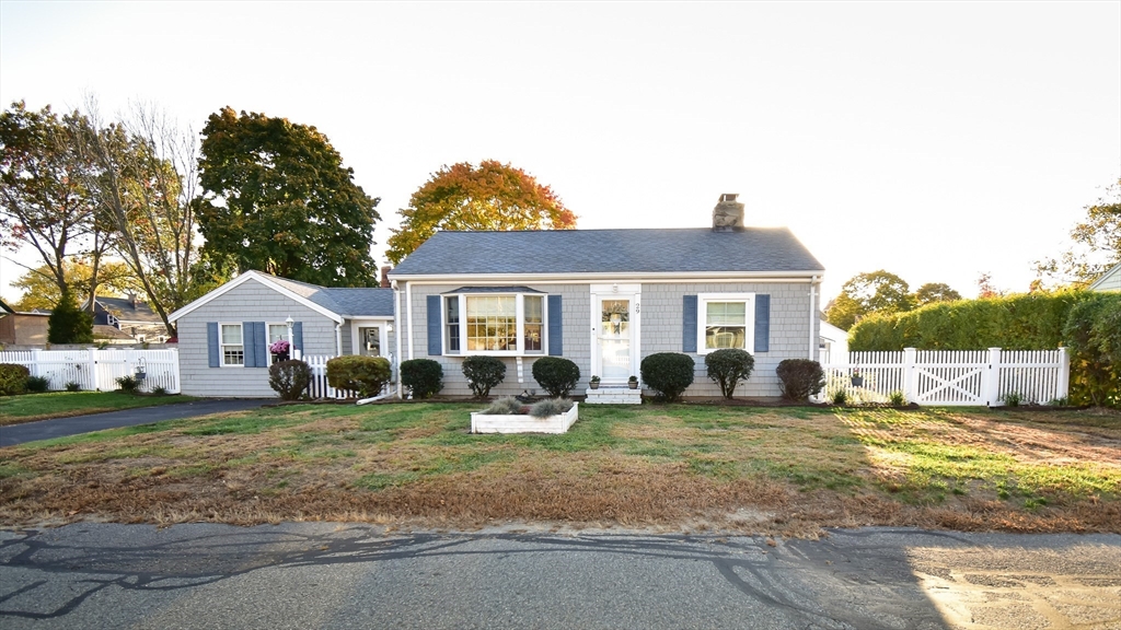 a front view of a house with a garden and trees