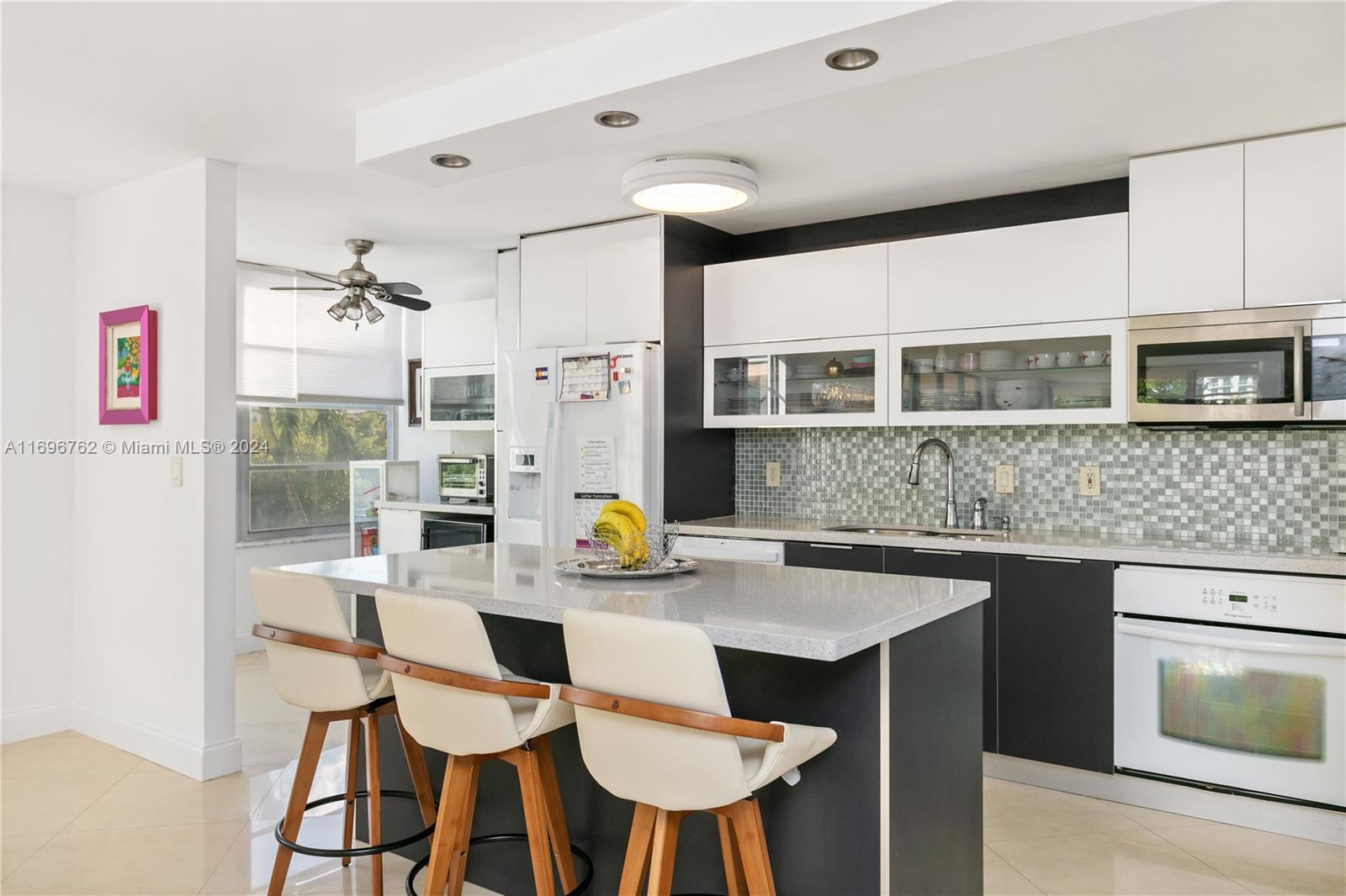 a kitchen with stainless steel appliances granite countertop a table chairs in it and wooden floors