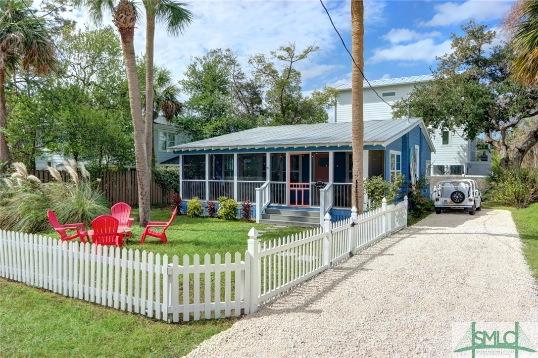 Front yard with picket fence and gravel driveway