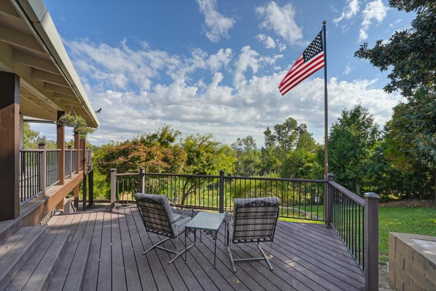 a view of a balcony with chairs and wooden floor