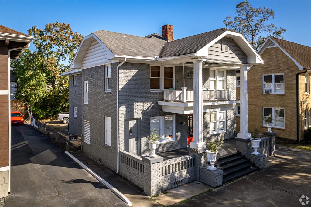 a view of a house with a small yard and deck