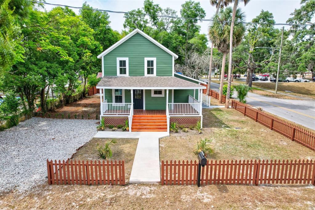 a view of a house with a yard and fence