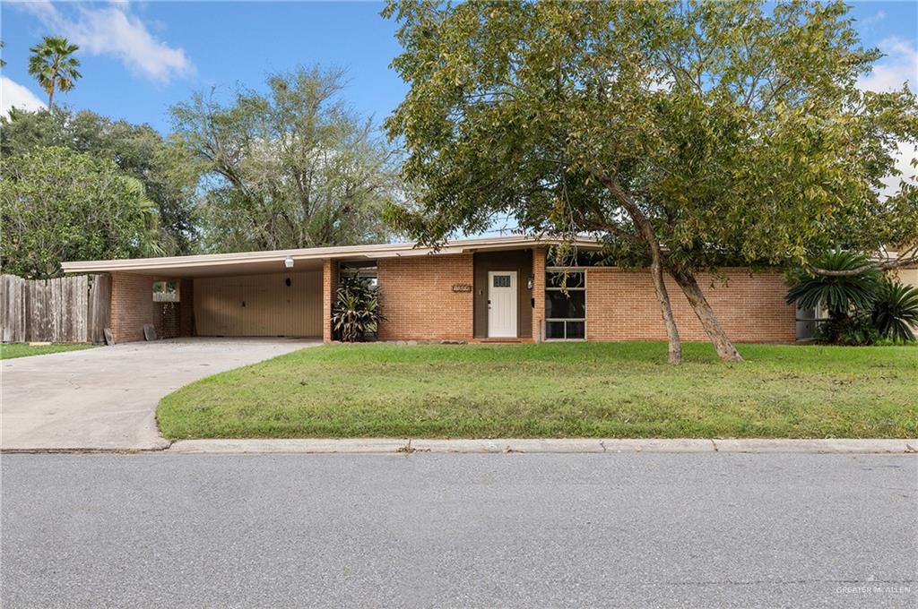 Ranch-style home with a front lawn and a carport