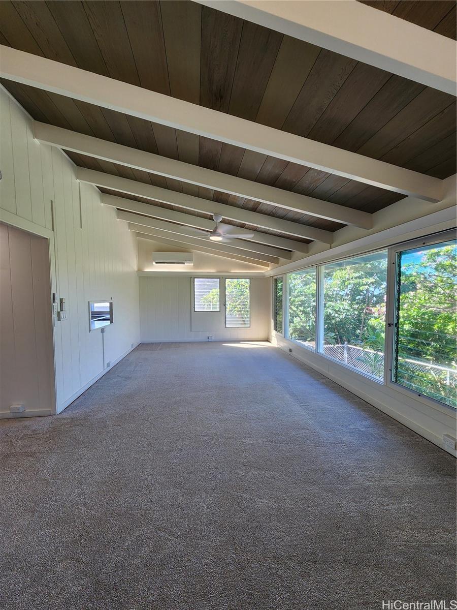 a view of a room with large windows and ceiling fan