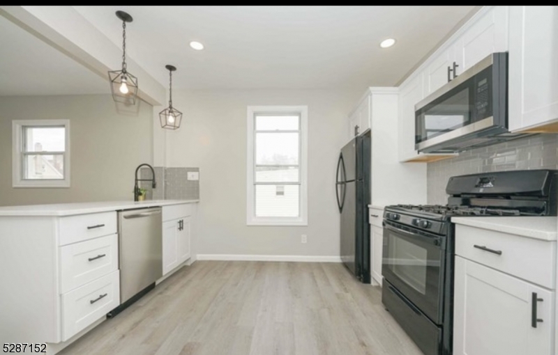 a kitchen with granite countertop a stove top oven sink and cabinets