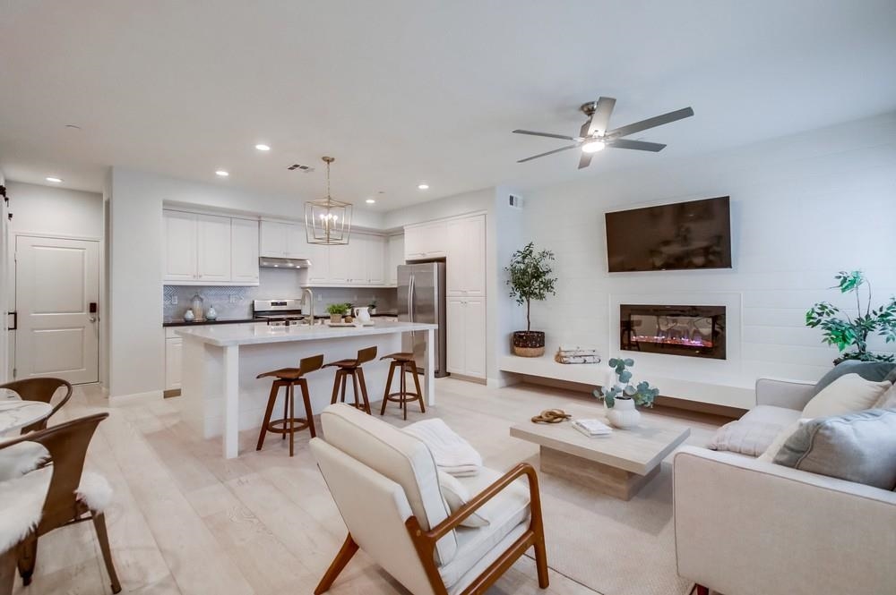 a living room with furniture kitchen view and a fireplace