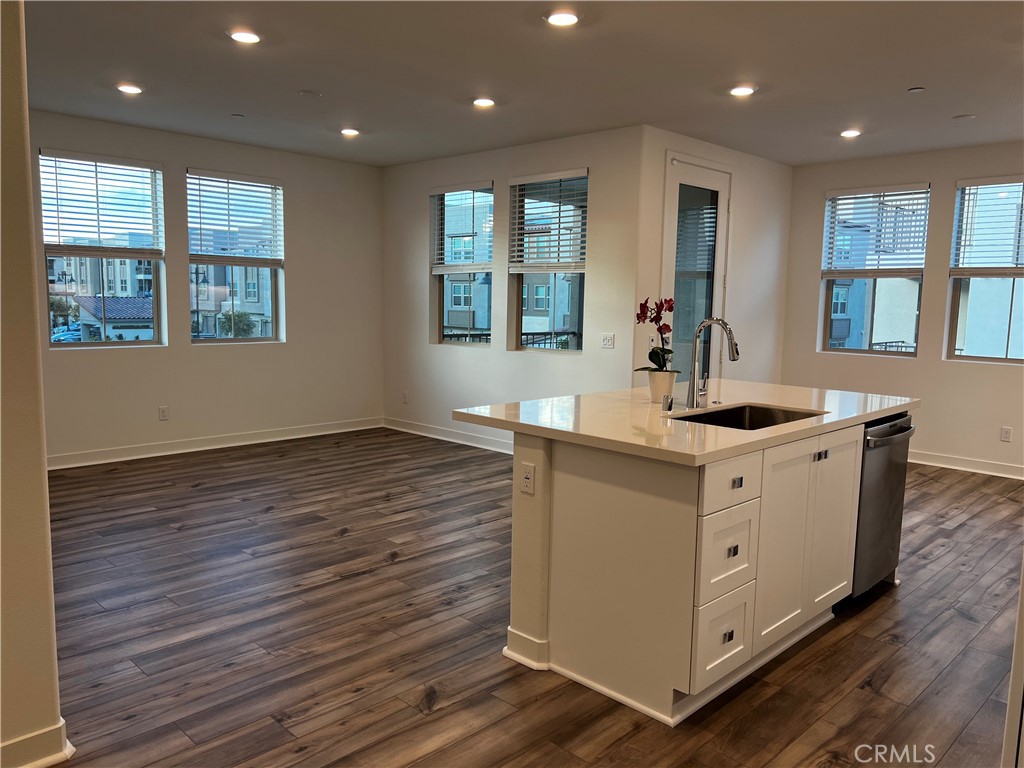 a kitchen with stainless steel appliances granite countertop a sink stove and wooden floor