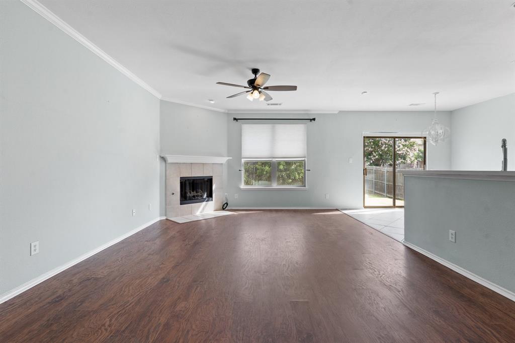 an empty room with windows and fireplace