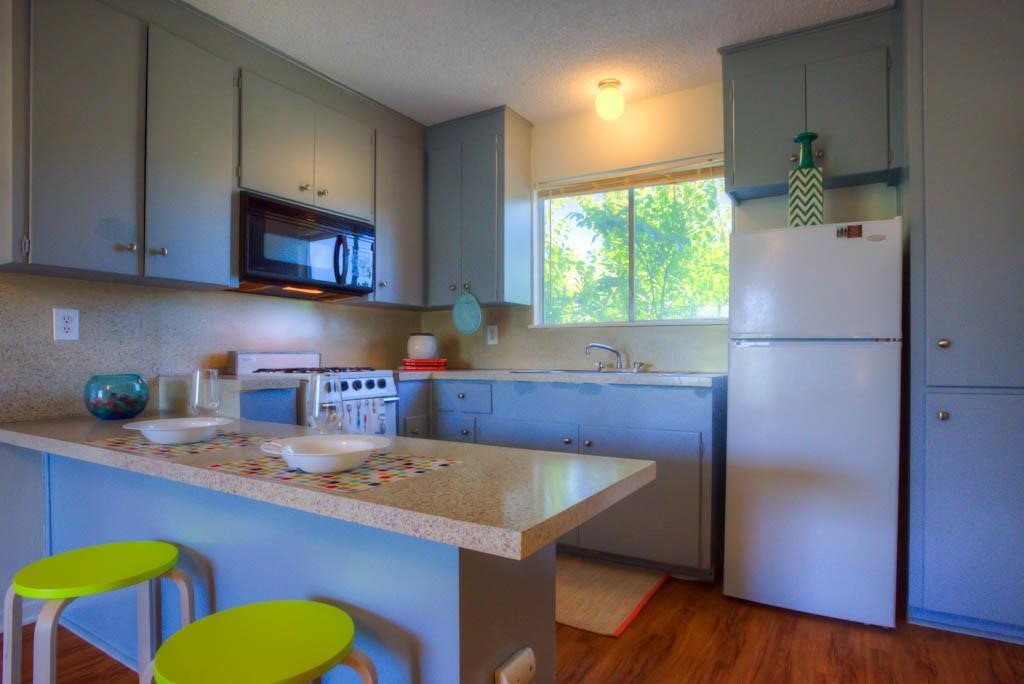 a kitchen with a refrigerator a sink and a stove top oven