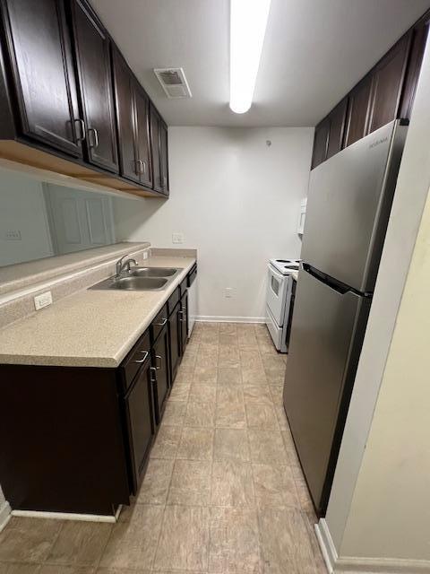 a kitchen with a sink a refrigerator and wooden floor