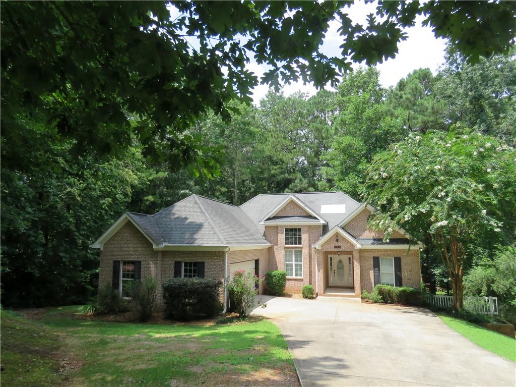 a front view of a house with a garden and trees