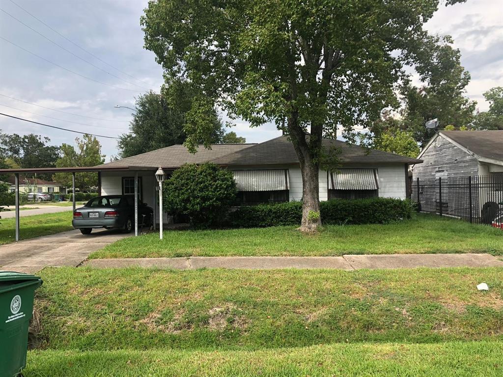 a view of a house with backyard and a tree