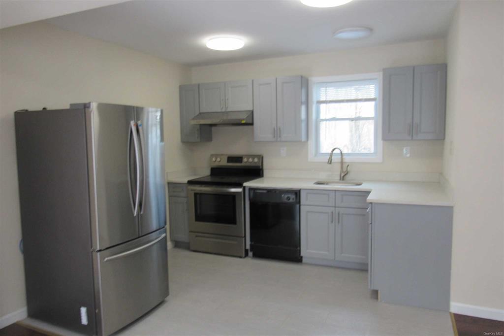 a kitchen with stainless steel appliances granite countertop a refrigerator and a sink