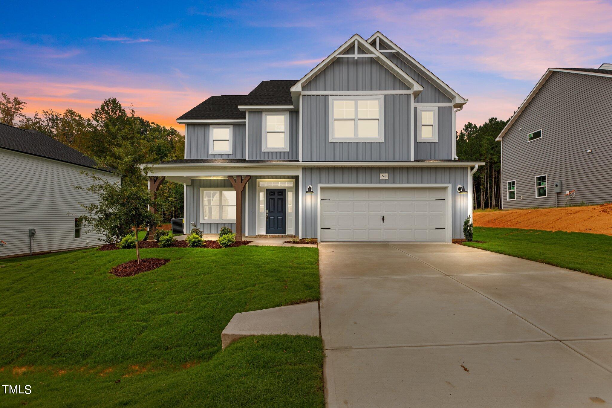 a front view of a house with a yard and garage