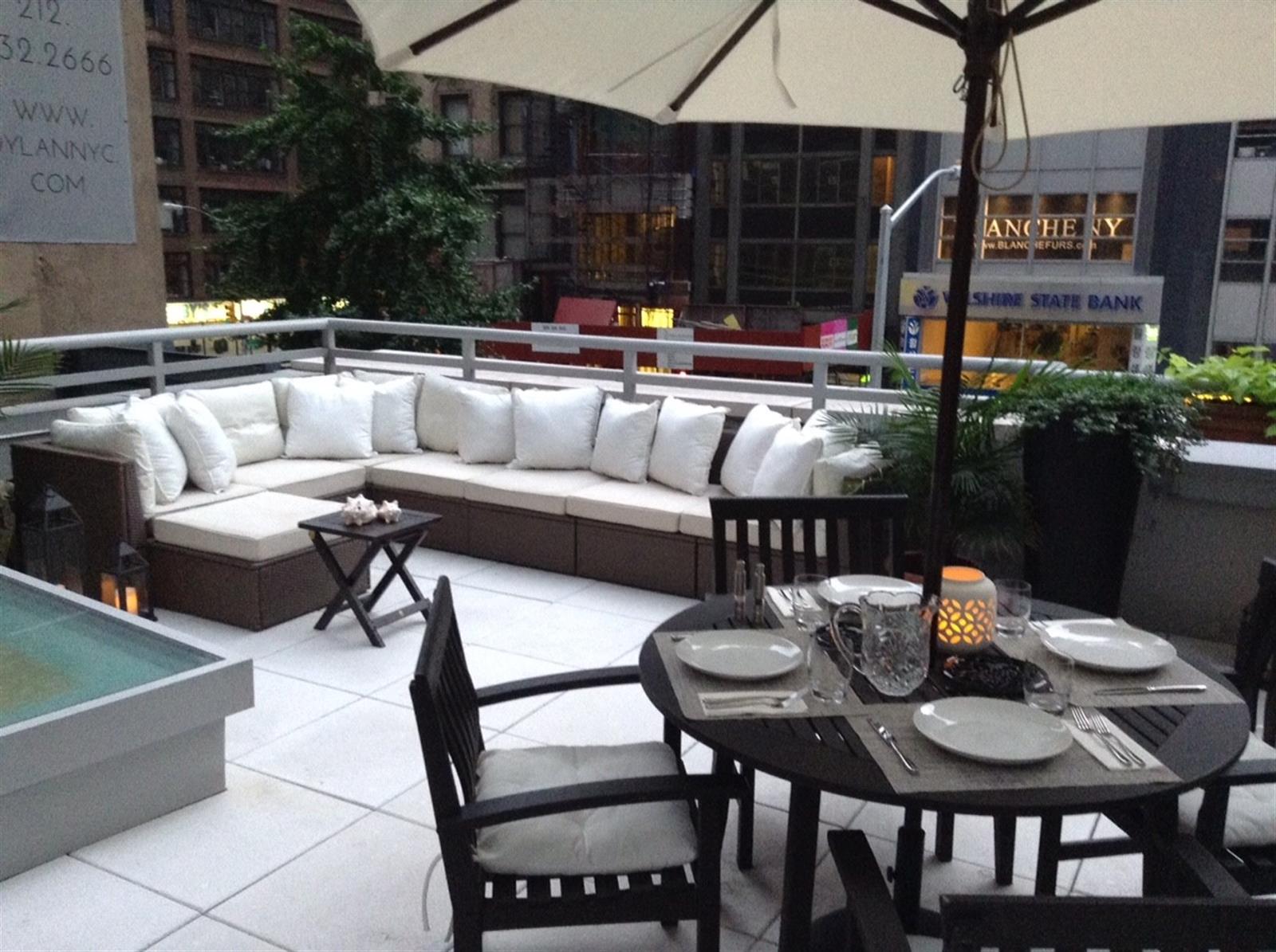 a view of a patio with couches table and chairs and potted plants