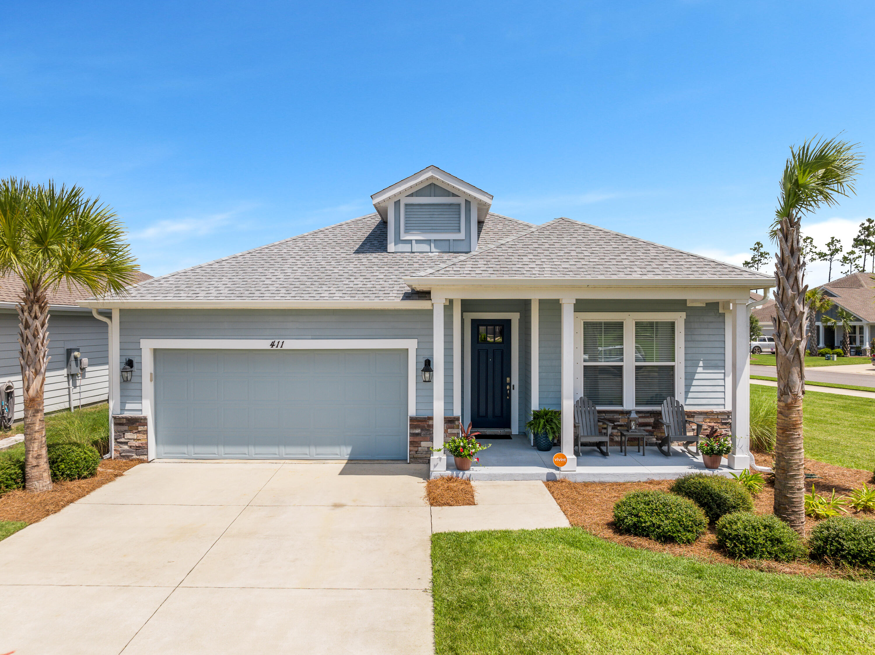 a front view of a house with porch and garden