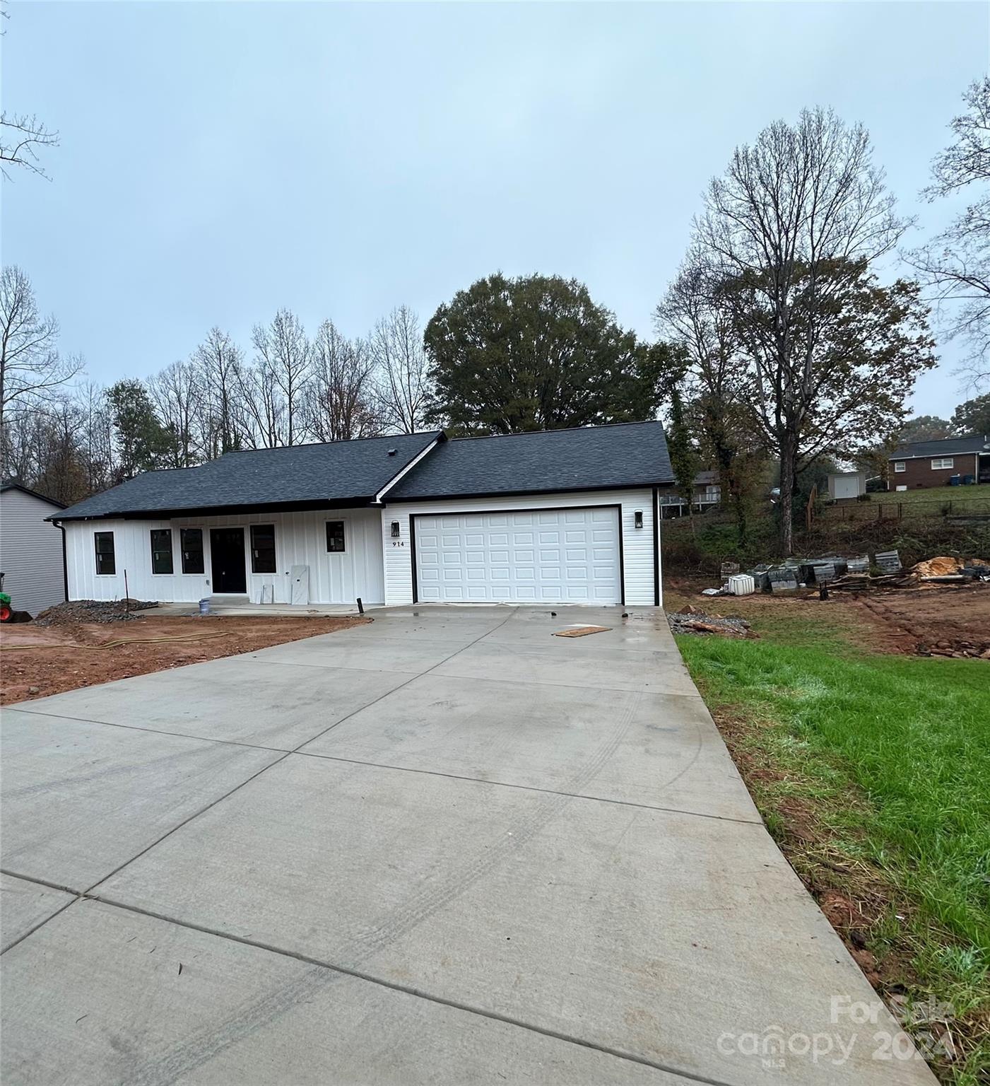 a front view of house with yard and trees in the background