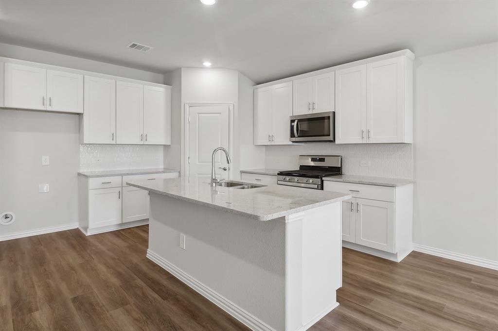 a kitchen with appliances a sink and cabinets