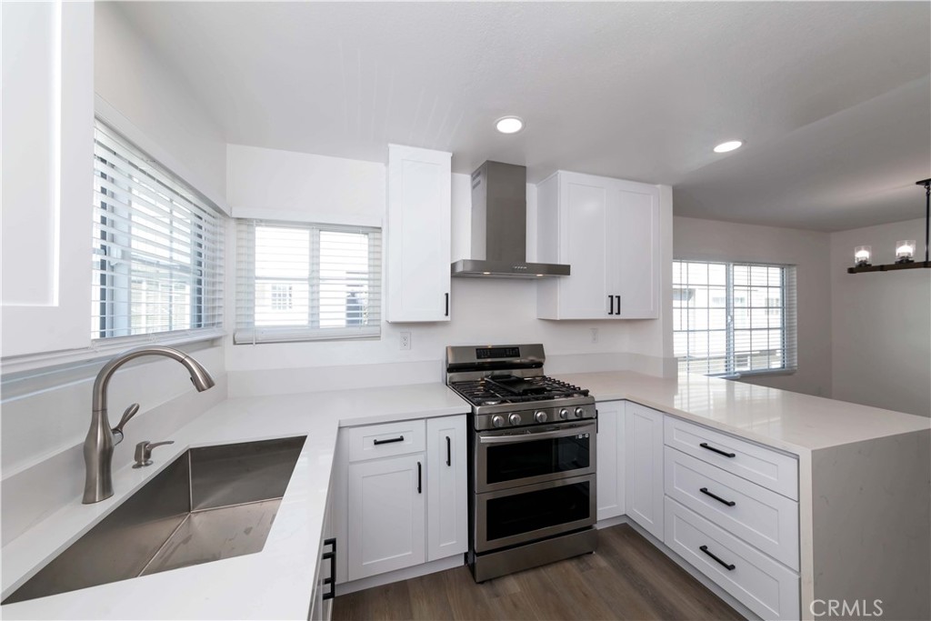 a kitchen with granite countertop a stove sink and cabinets