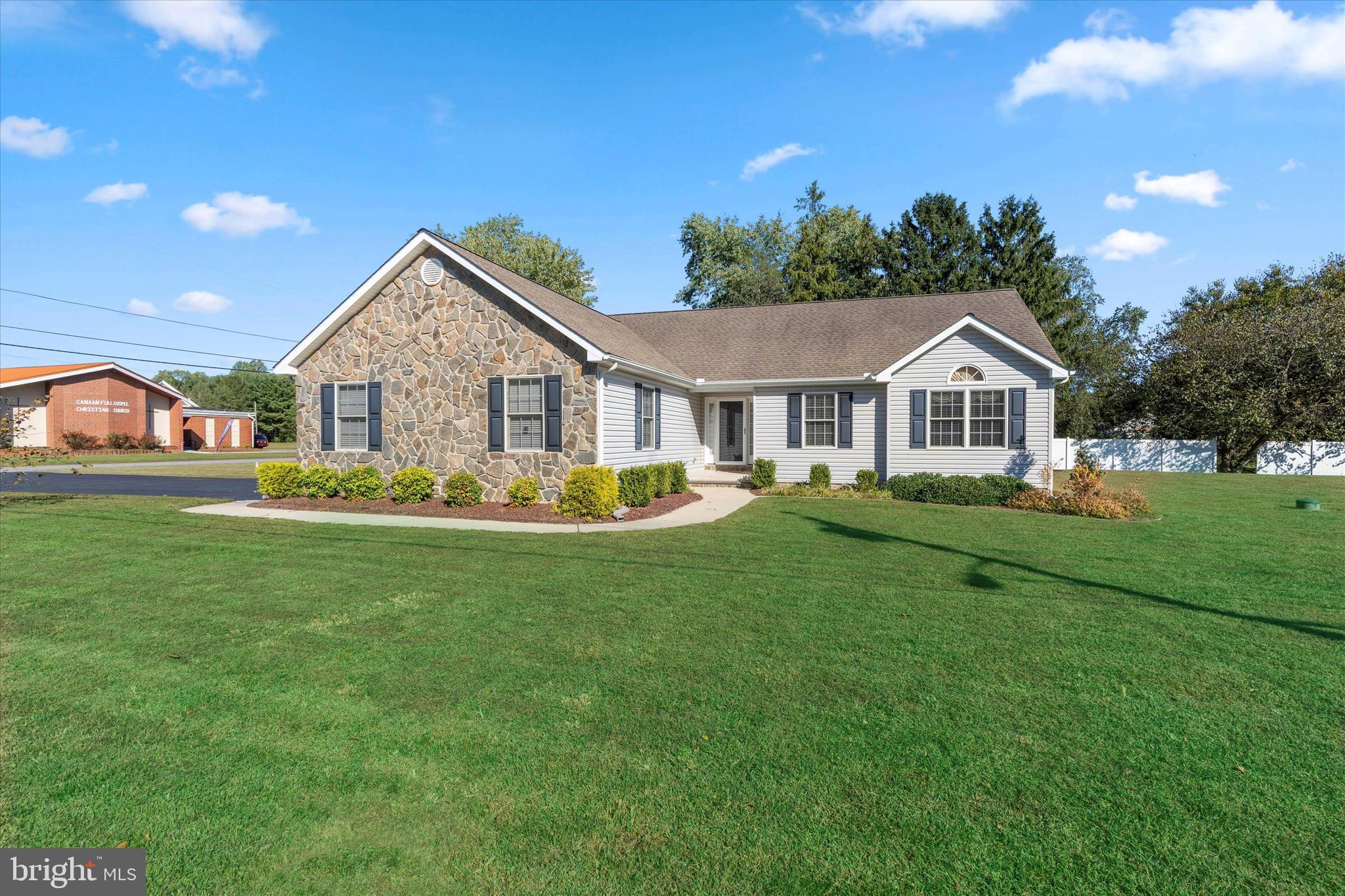 a front view of a house with a garden and yard