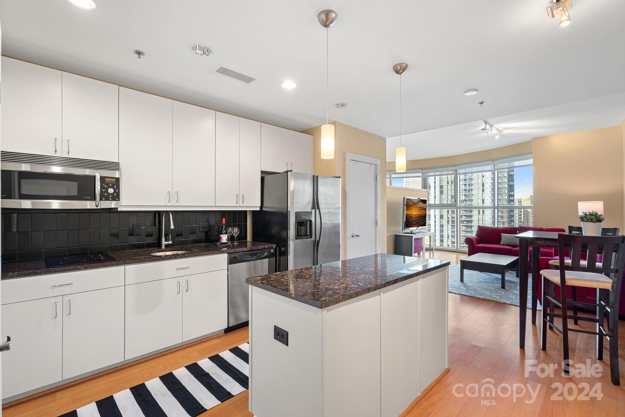 a kitchen with stainless steel appliances kitchen island granite countertop a sink and cabinets