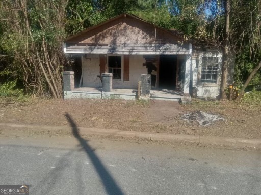 a view of a house with large windows and a small yard