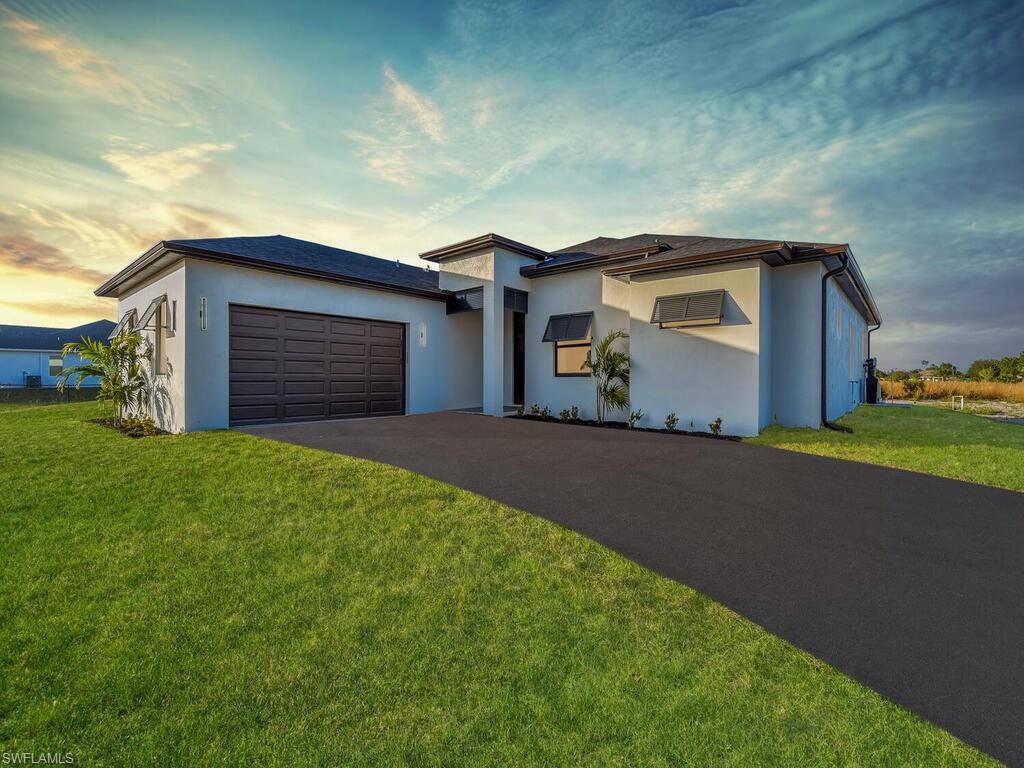 View of front of house with a lawn and a garage