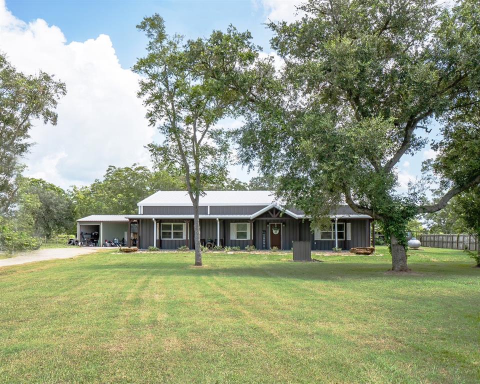 a front view of house with yard barbeque and outdoor seating