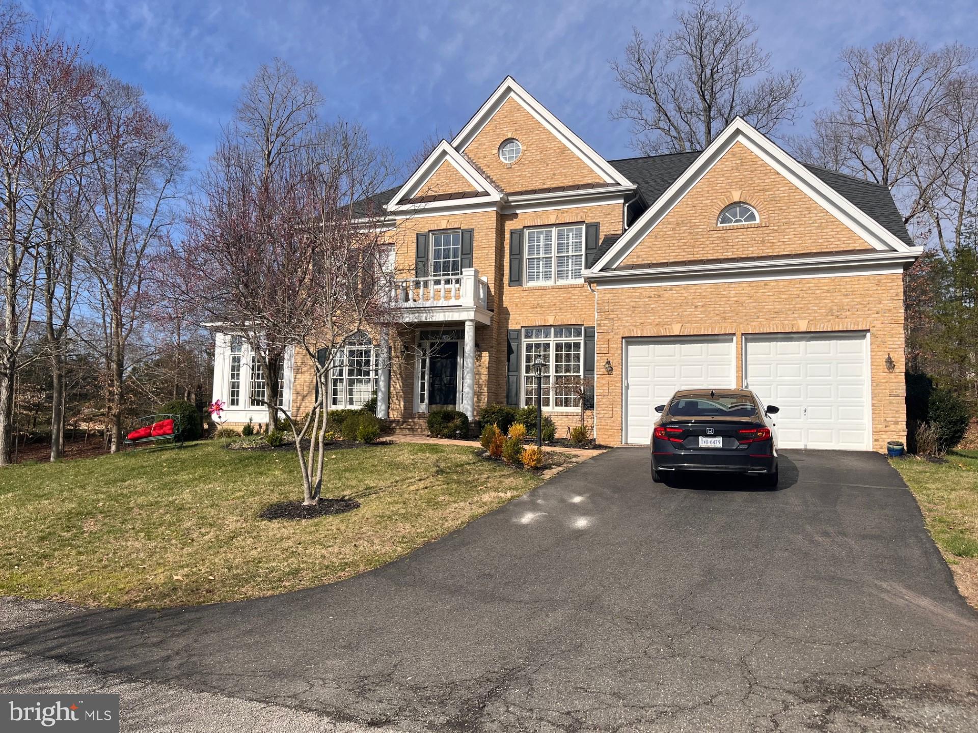 a front view of a house with a garden and parking space