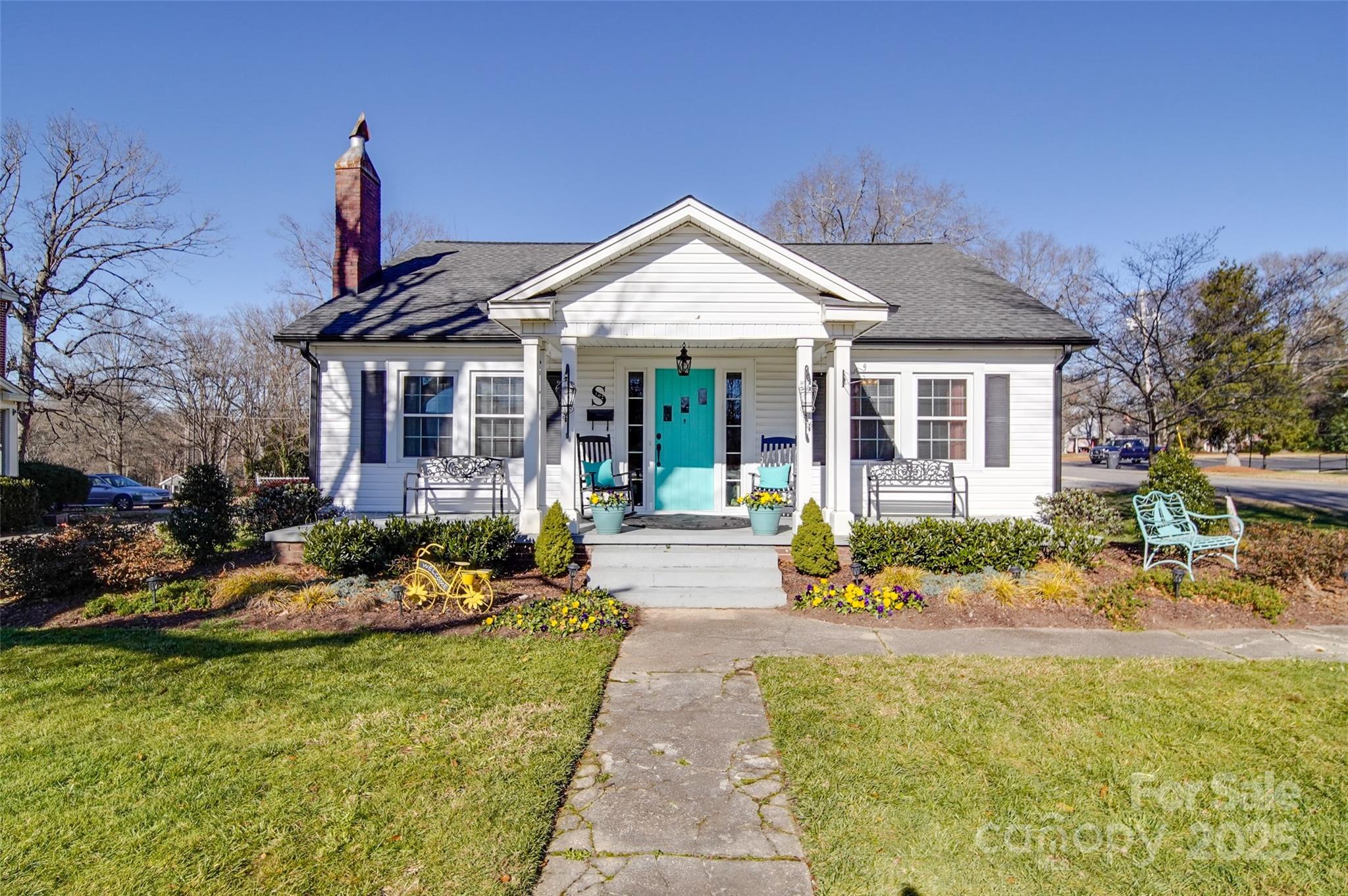 a front view of a house with a garden and plants